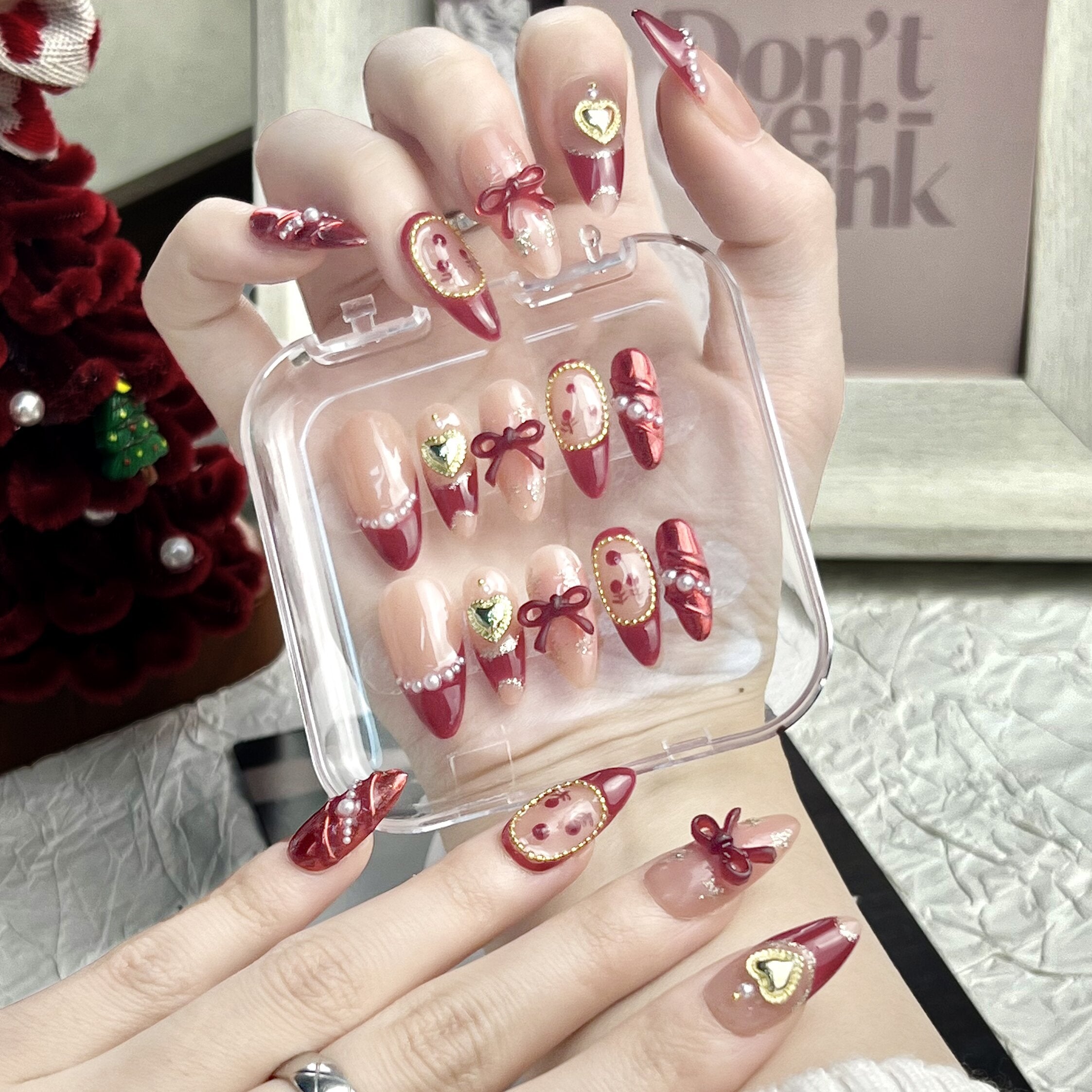 NAILOVE Red French-style pearls with bow decorations adorn the Christmas manicure.